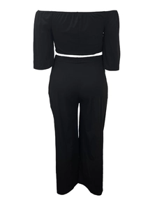 Rear view of black off-shoulder long sleeve crop top and matching high-waist wide-leg pants
