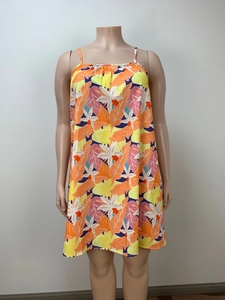Detail eines tropischen Blumenmusters auf losem Trägerkleid mit kräftigen Orangetönen