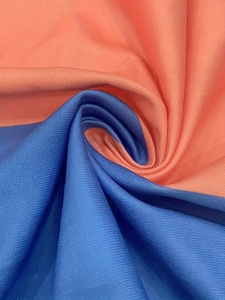 Close-up of blue and orange striped textured fabric with a soft pleated spiral twist