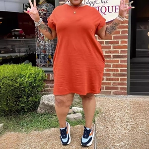 Detail showing loose-fit short-sleeve solid color dress in orange cotton fabric