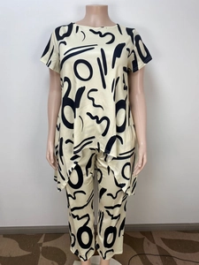 Detail of loose-fit two-piece set featuring abstract black print on beige fabric