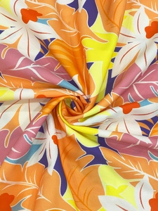 Detail von weichem Tropen-Blattdruckstoff in leuchtenden Orange-, Gelb- und Pinktönen