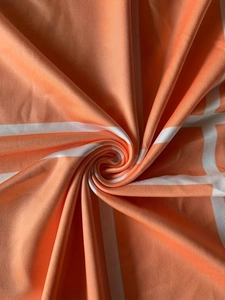 Macro shot of orange and white checkered elastic fabric with fine knit texture