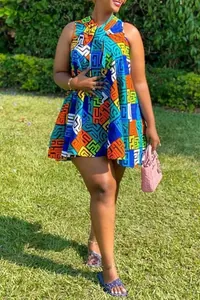 Detail of multi-color geometric print dress with neckline bow on a sunny lawn