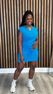 Full-body view of a slim fit blue sleeveless mini dress paired with white sneakers