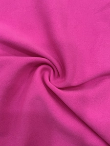 Macro shot of rose pink fine-knit fabric showing smooth fiber texture and drape