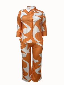 Detail of loose fit two-piece set with long sleeve button shirt and orange abstract pattern