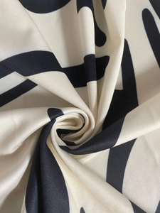 Detailed macro shot of black and white geometric pattern fabric with silky texture