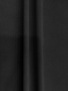 Detailed macro shot of high-quality black pleated fabric with vertical texture and soft drape