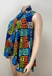 Detail of high-neck sleeveless top featuring vibrant geometric patterns on black fabric