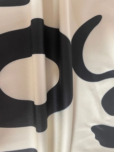 Detailed close-up of geometric printed fabric texture with smooth satin finish