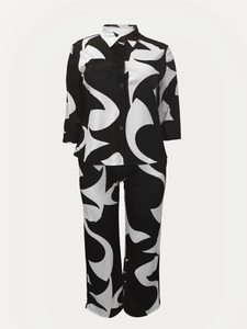 Detail of loose-fit black and white abstract print shirt and trousers set with button closure