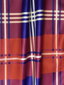 Macro shot of striped bodycon skirt fabric showing textured red and blue plaid pattern