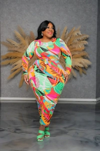 Detail of plus size long sleeve dress featuring vibrant tropical floral print and matching belt