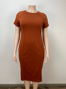 Detail view of the burnt orange knit fabric and raglan sleeve seams on the casual dress