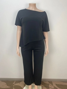 Detail of black lounge set with asymmetrical hem short sleeve top and high waist trousers