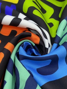 Close-up of colorful abstract letter print on textured canvas fabric with elegant folds