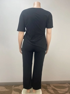 Back view of black two-piece casual set featuring asymmetric hem top and wide-leg pants