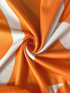 Macro shot of orange and white striped fabric with smooth texture and high elasticity