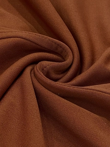 Macro shot of dark brown fine-ribbed knit fabric showing detailed texture and high elasticity