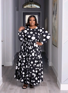 Détail d'une robe noire à manches longues avec gros pois blancs et ceinture assortie