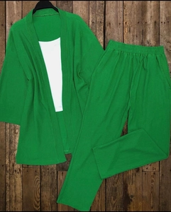 Detailansicht eines hellgrünen, gerippten dreiteiligen Loungewear-Sets auf Holzgrund