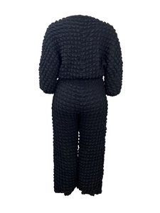 Rear view of black two-piece set featuring textured bubble fabric and a loose comfort fit
