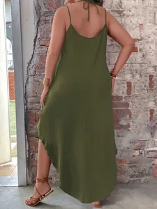 Olive green backless maxi dress with spaghetti straps and side slit on brick background