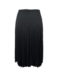 Détail des plis verticaux fins d'une jupe midi trapèze noire avec un drapé élégant