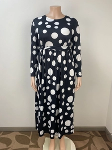 Détail de robe longue à pois noir et blanc avec ceinture à la taille haute et manches longues