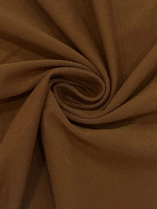 Detailed texture of brown linen fabric showing natural woven fibers and soft drape