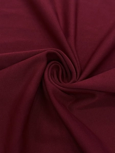 Detailed macro shot of burgundy knit fabric texture and soft drape of the dress