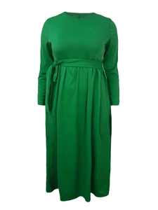 Detail of emerald green long-sleeved dress showing waist tie and pleated knit fabric texture