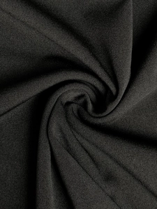 Close-up of premium black knitted fabric texture showing soft drape and fine grid pattern