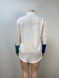 Detail showing the curved hem and unique asymmetric color-blocked cuffs on white shirt