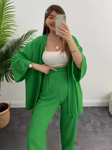 Dreiteiliges Damen-Freizeitset mit grünem Cardigan, weiter Hose und weißem bauchfreiem Top