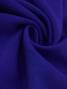 Macro close-up of textured deep blue knit fabric with soft drapes and fine weave