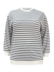 Detail of white ribbed cuffs and hem on a black and white striped long sleeve sweatshirt