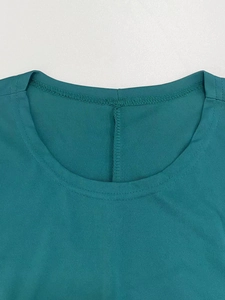 Detail of the high-quality round neckline and neat stitching on dark green knit dress
