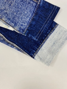 Detail der Kleid-Manschette mit Denim-Struktur-Druck und weißen Ziernähten
