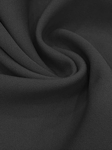 Detailed macro view of black woven fabric texture with fine grain and elegant drape