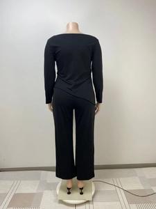 Detail view of the black two-piece lounge set featuring an asymmetric hem from behind