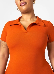 Detail of orange short-sleeve polo dress with V-neck collar and textured knit fabric