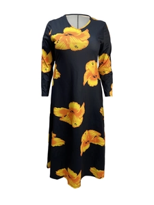 Detail of long-sleeve maxi dress with large yellow and orange floral prints on black fabric