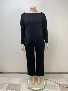 Detail of black two-piece loungewear set featuring asymmetric hem top and straight trousers