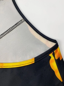 Close-up of V-neck stitching and vibrant floral print on soft black fabric material