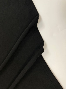 Close-up of black knitted fabric showing fine stitching and high-density texture detail