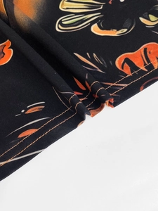 Detail shot of black floral dress hem with orange double-needle stitching and fabric print