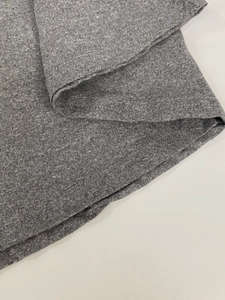 Detailed macro view of the double-stitched hem on a grey heather knit long sleeve dress