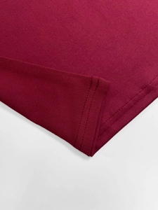 Close-up of double-needle hem stitching and texture on burgundy knit dress fabric